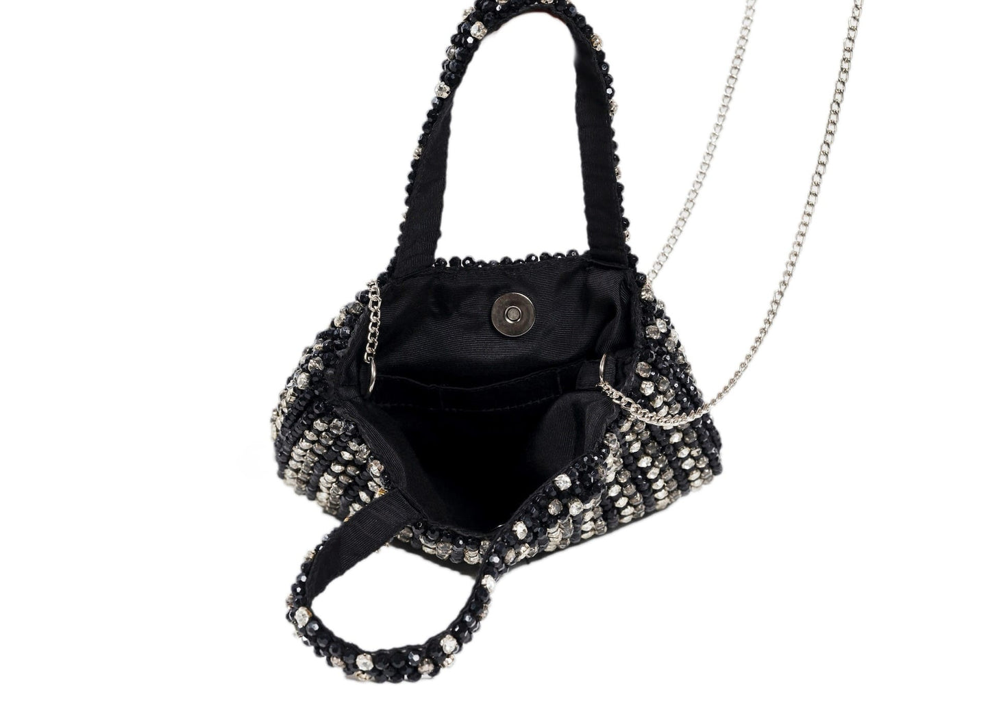 Inside black compact evening purse with a striking silver beaded burst pattern, handcrafted Indian artisanal accessory.