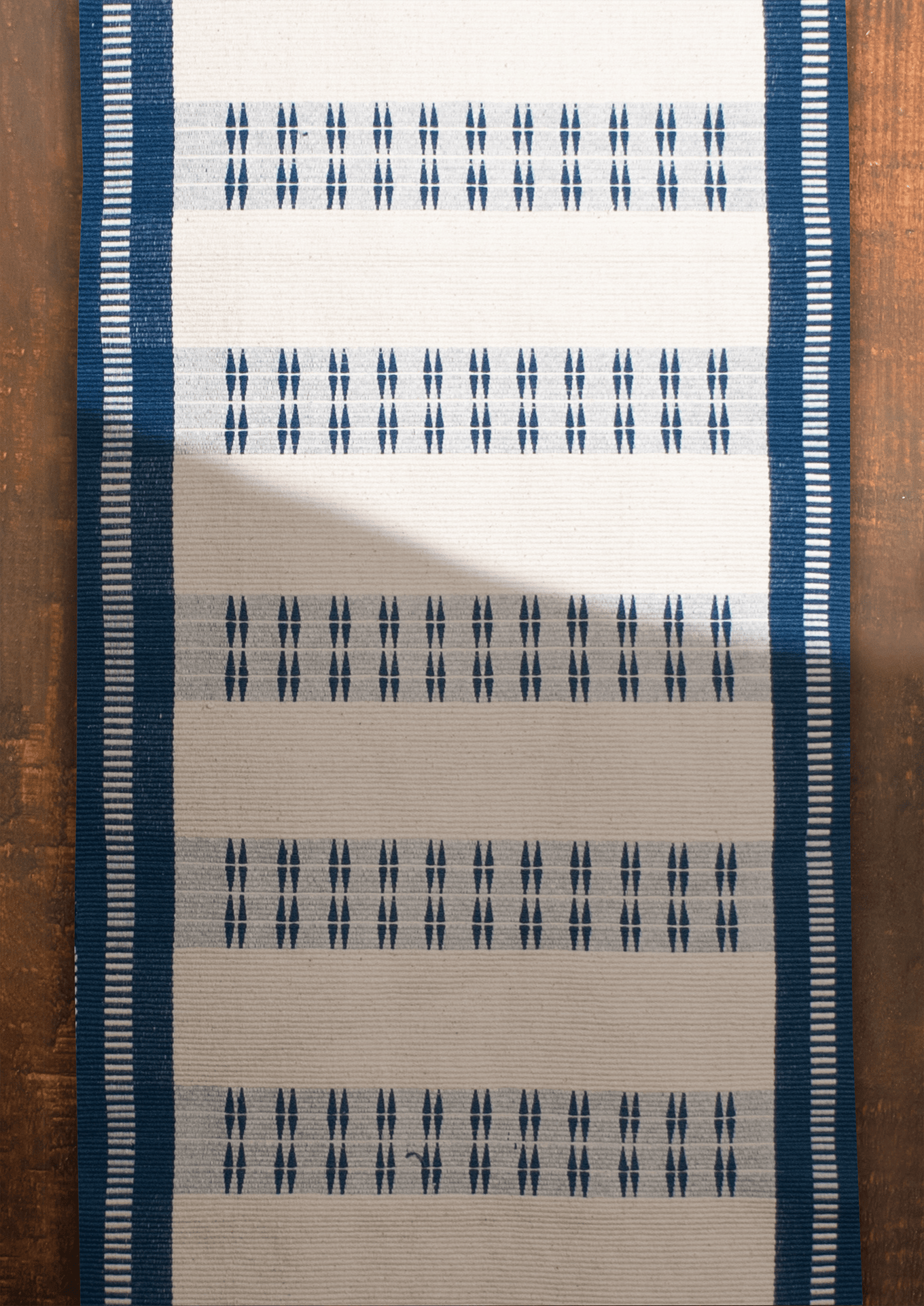 Handwoven cotton Chakesang table runner with geometric navy blue patterns, traditional Naga textile.