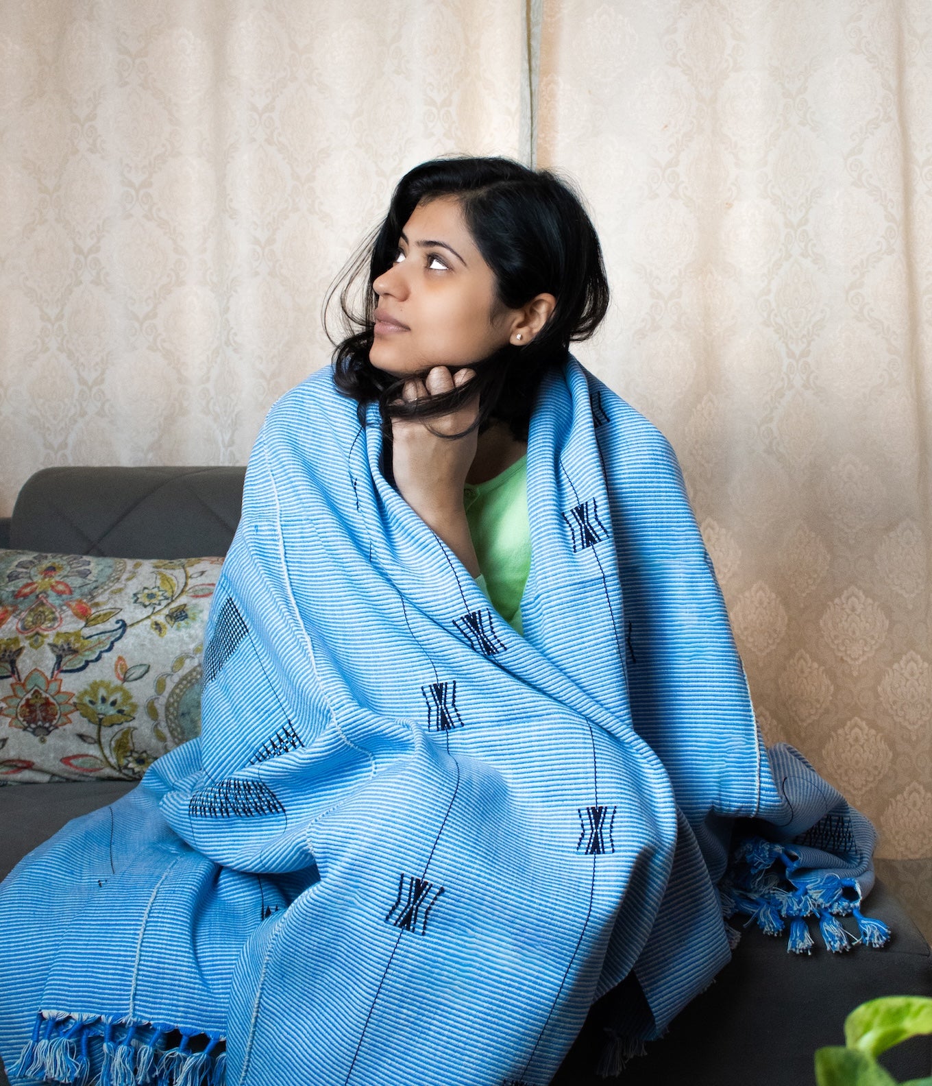Soft light blue cotton throw draped over a person, premium Indian handcrafted home accessory.