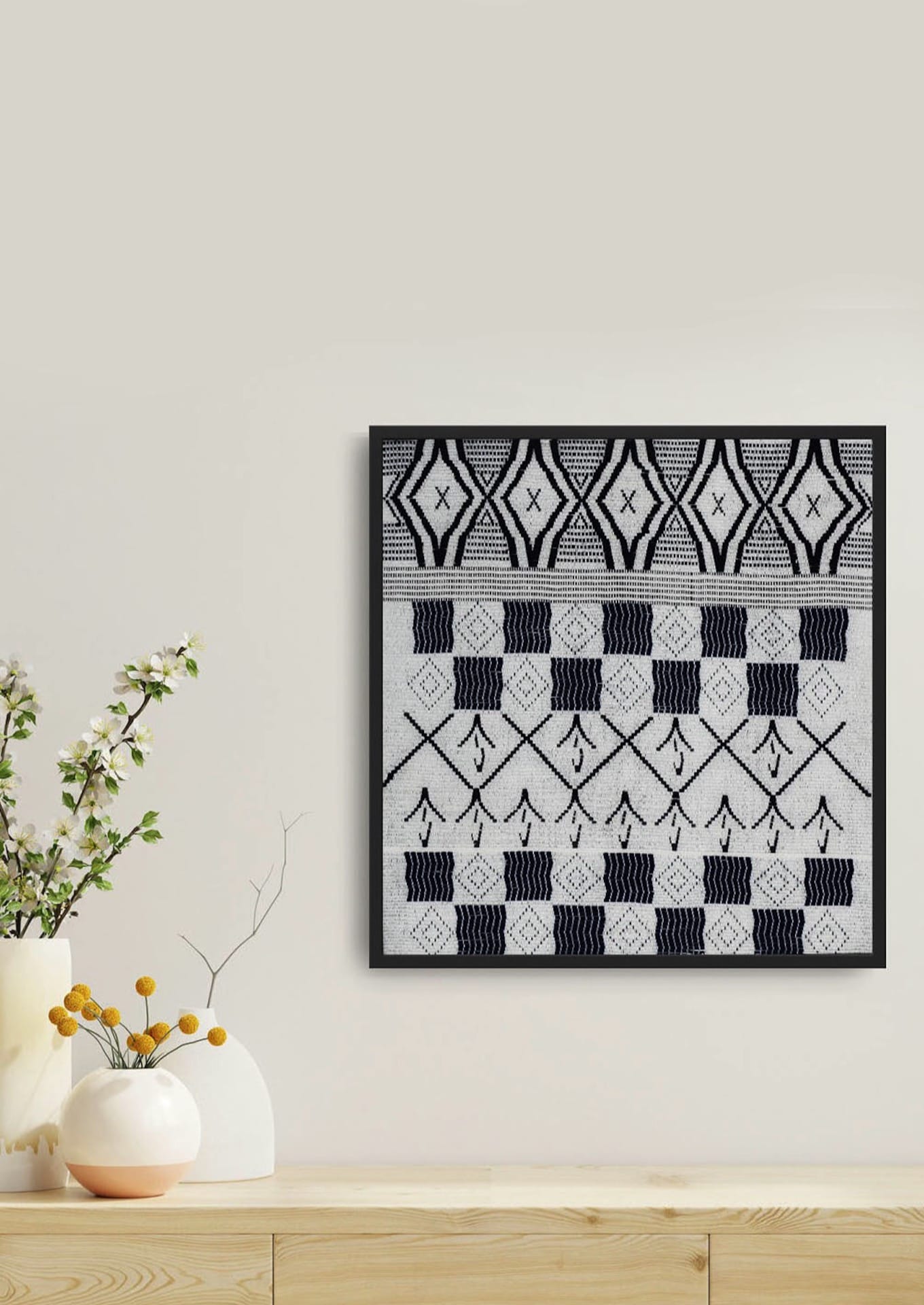 Intricate geometric weaving on a framed cotton textile above wooden cabinet with plants, premium Indian heritage wall decor.