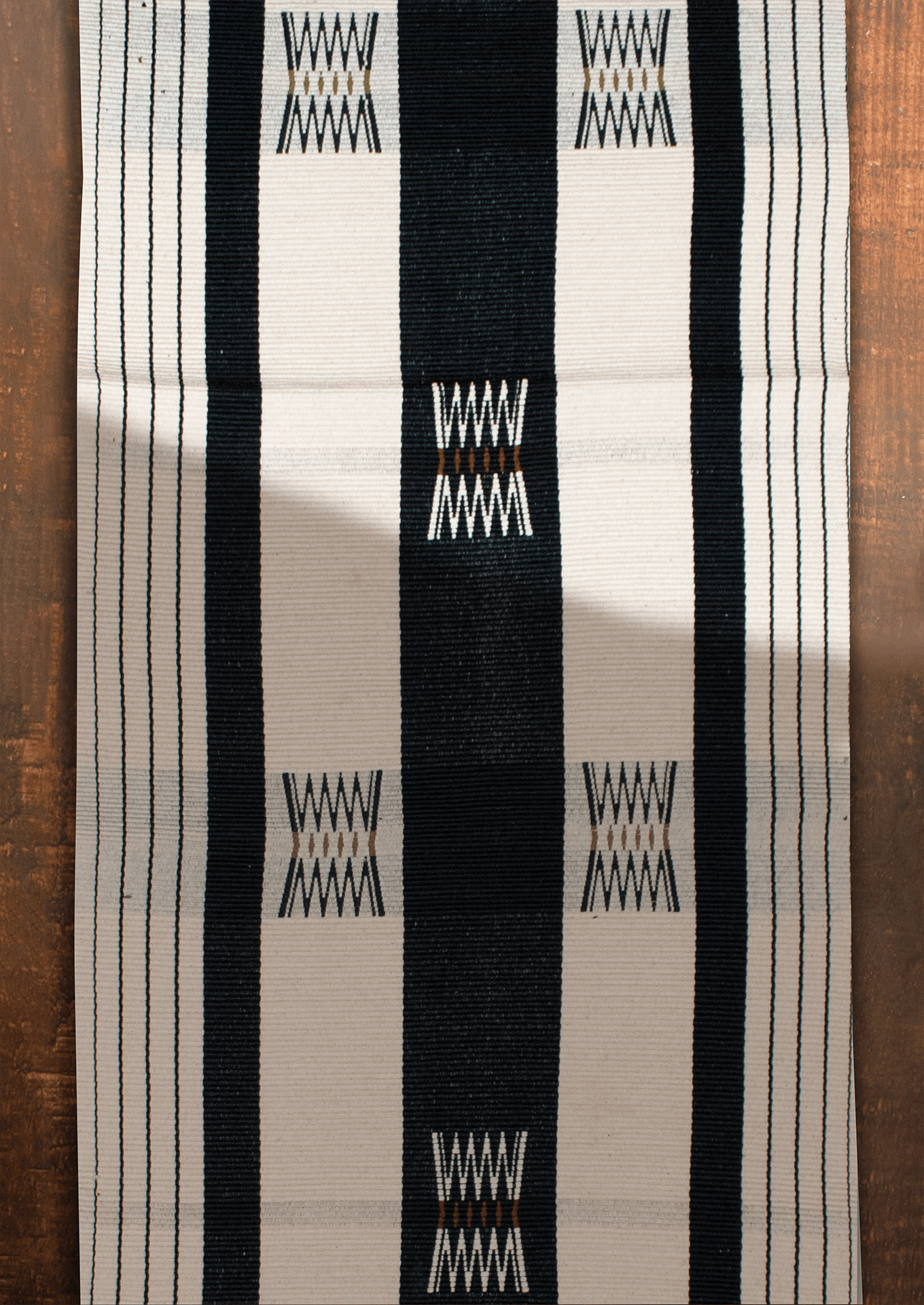 Handwoven dark Tenyimi table runner with green accents, authentic Naga loin loom textile.