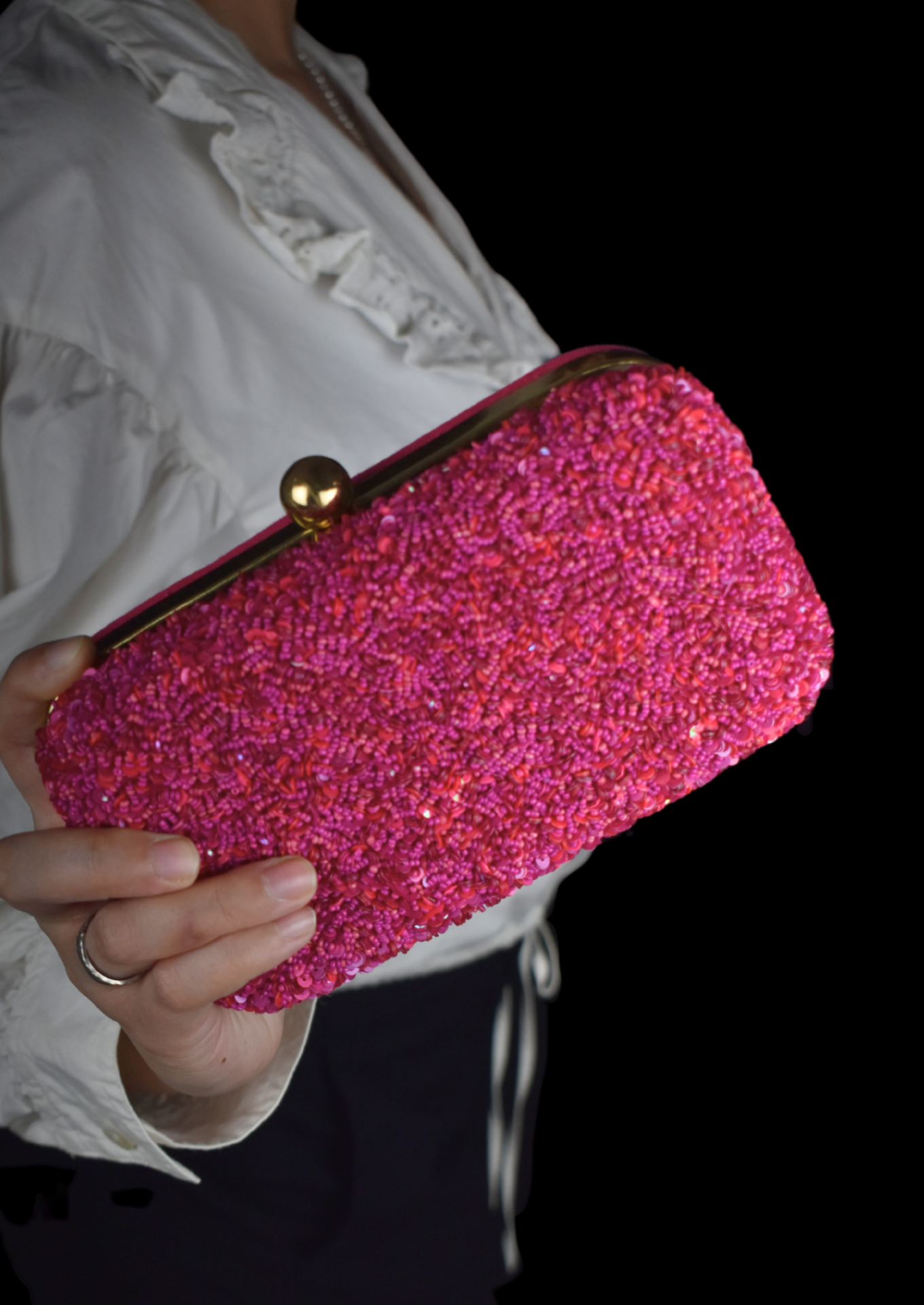 Shimmering hand-sewn pink beadwork on an elegant clutch, authentic Uttar Pradesh fashion.