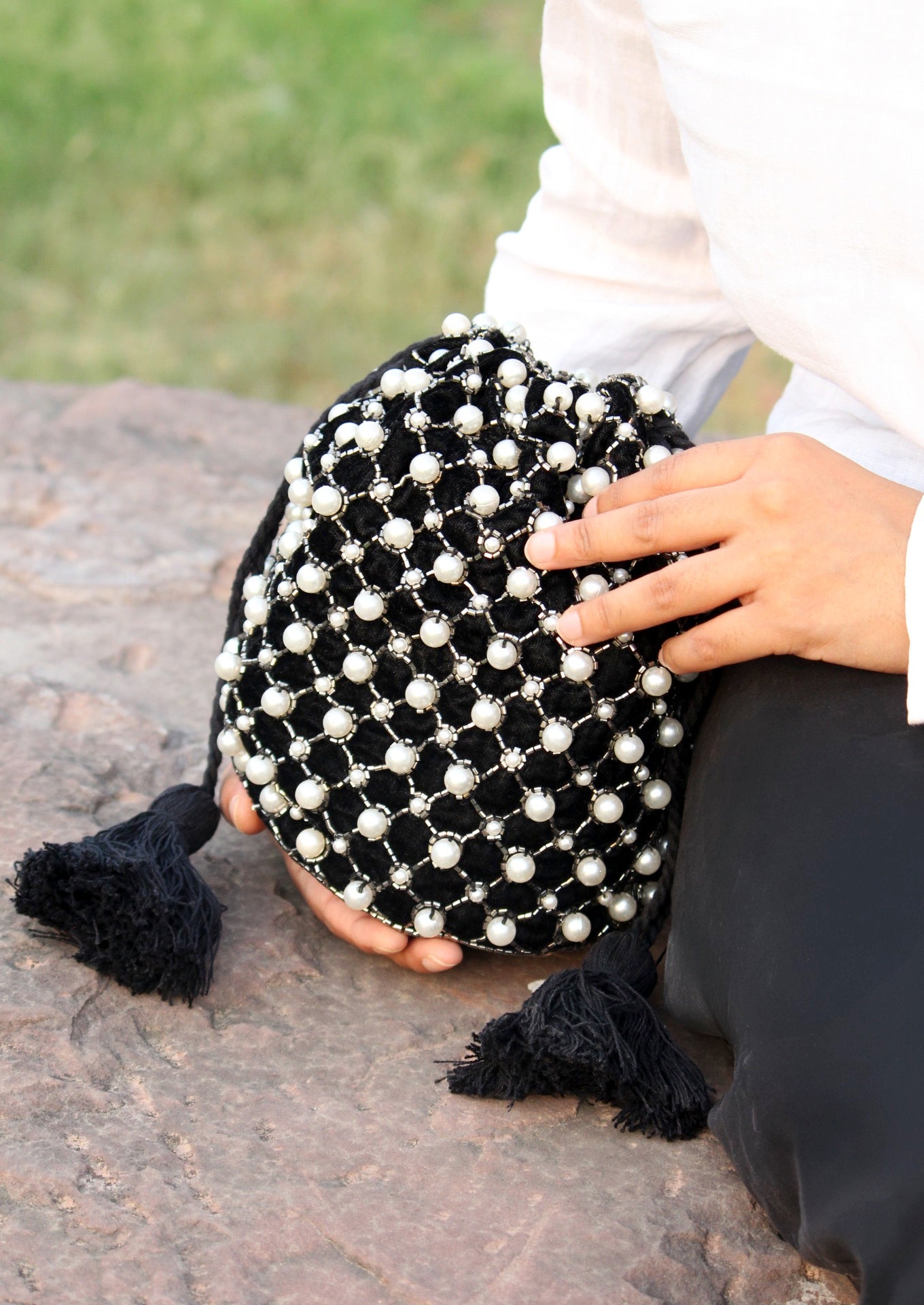 Black potli bag hand-embroidered with white pearl beads, premium Indian artisanal handbag.