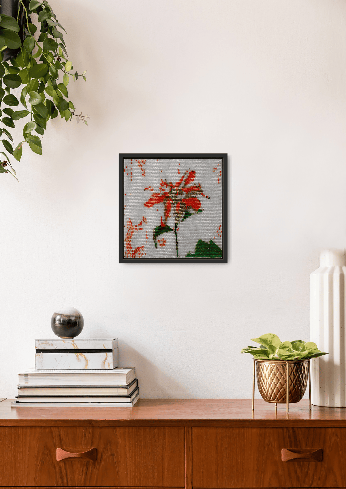 Hand-stitched orange flower glass bead design on a white wall, authentic Indian heirloom room art.
