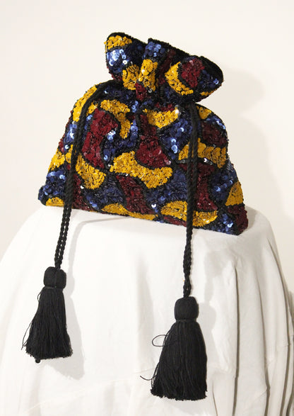 Colorful embroidered Segmenta potli bag with black tassels, sustainable Indian handicraft.