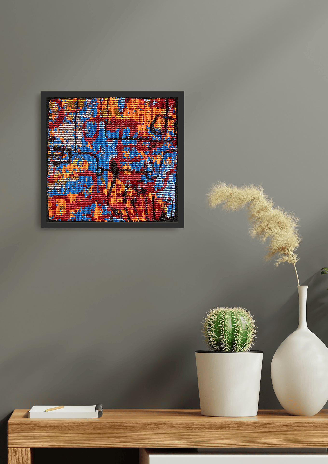 Lifestyle view of geometric glass bead wall art on a shelf, authentic Indian room decor.
