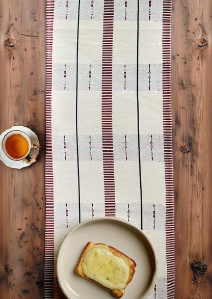 Traditional loin loom cotton table runner on a dining table, premium Indian home textiles.