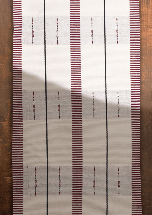 Handwoven cream cotton Angami table runner with maroon stripes, authentic Naga handicraft.