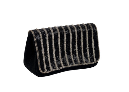 Diagonal view of black evening purse with silver wave pattern beadwork, premium Indian handcrafted accessory.
