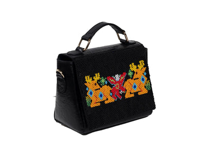 Diagonal view of vegan black banana leather purse with yellow deer beadwork, handcrafted premium Indian accessory.