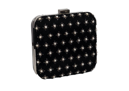 Diagonal view of black fabric evening clutch with metallic star beadwork, handcrafted premium Indian accessory.