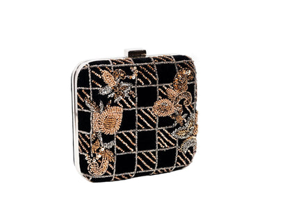 Diagonal view of black and gold checkerboard beaded evening clutch, handcrafted premium Indian luxury accessory.