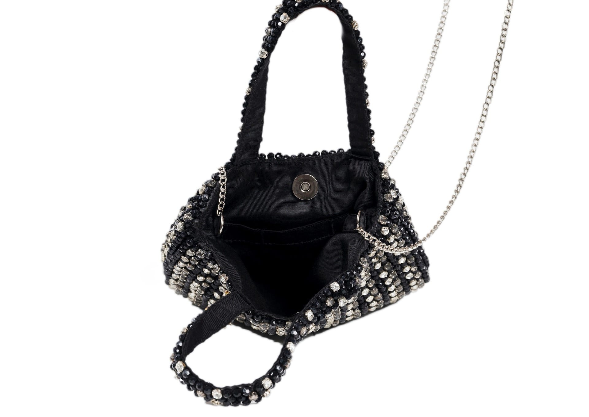 Inside black compact evening purse with a striking silver beaded burst pattern, handcrafted Indian artisanal accessory.