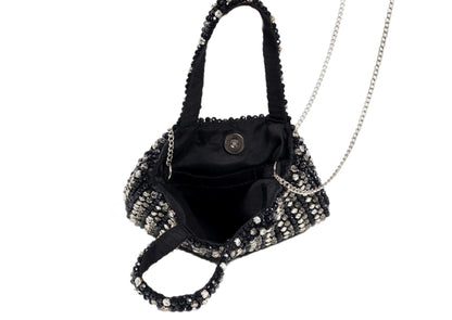 Inside black compact evening purse with a striking silver beaded burst pattern, handcrafted Indian artisanal accessory.