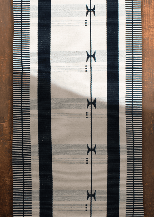 Handwoven black and white Kutsapo table runner with maroon details, traditional Naga loin loom art.