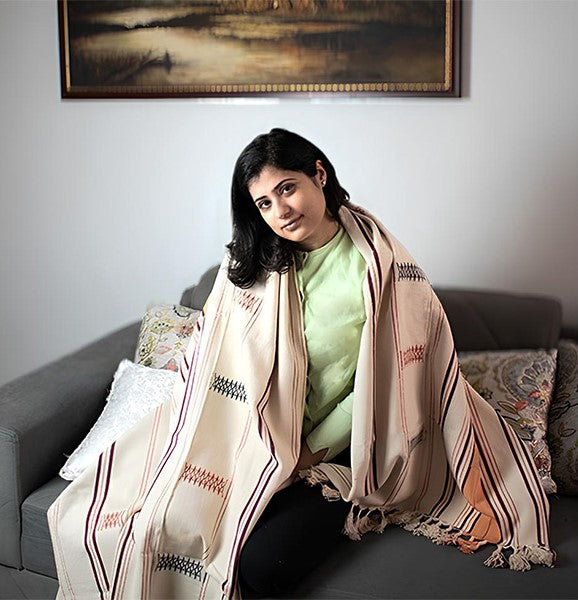 Elegant cotton throw draped over a person on a sofa, premium Indian cultural craftsmanship.
