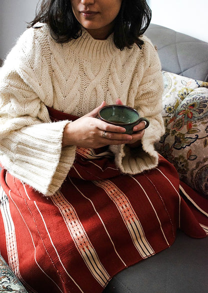 Cozy red cotton throw styled over a sofa, authentic Indian artisanal home decor.