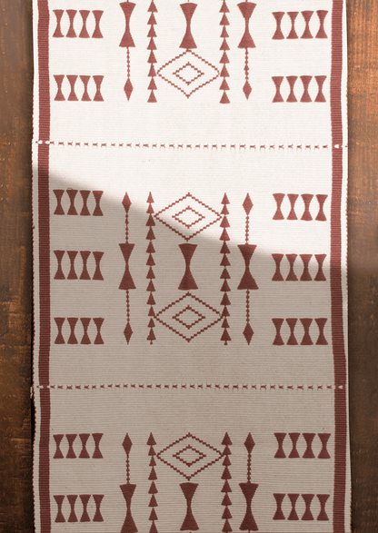Handwoven cream cotton Tekru table runner with red tribal motifs, authentic Naga loin loom textile.