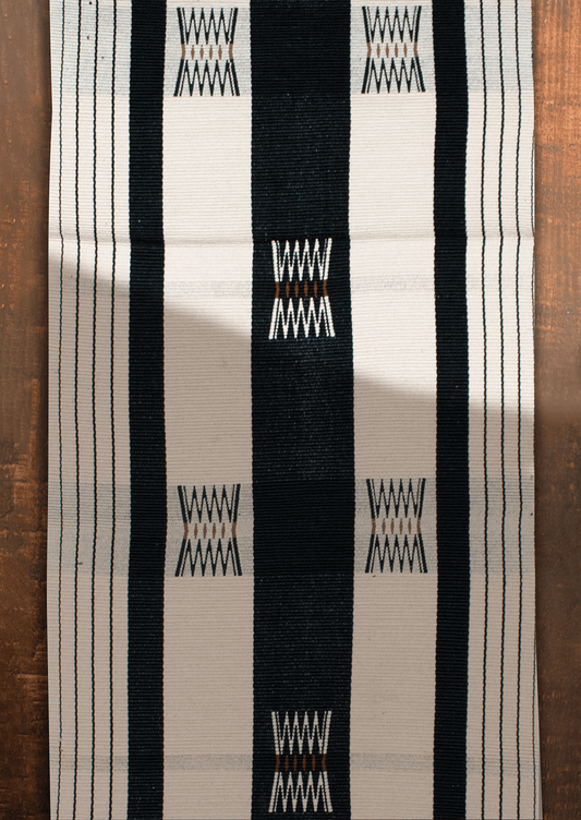 Handwoven dark Tenyimi table runner with green accents, authentic Naga loin loom textile.