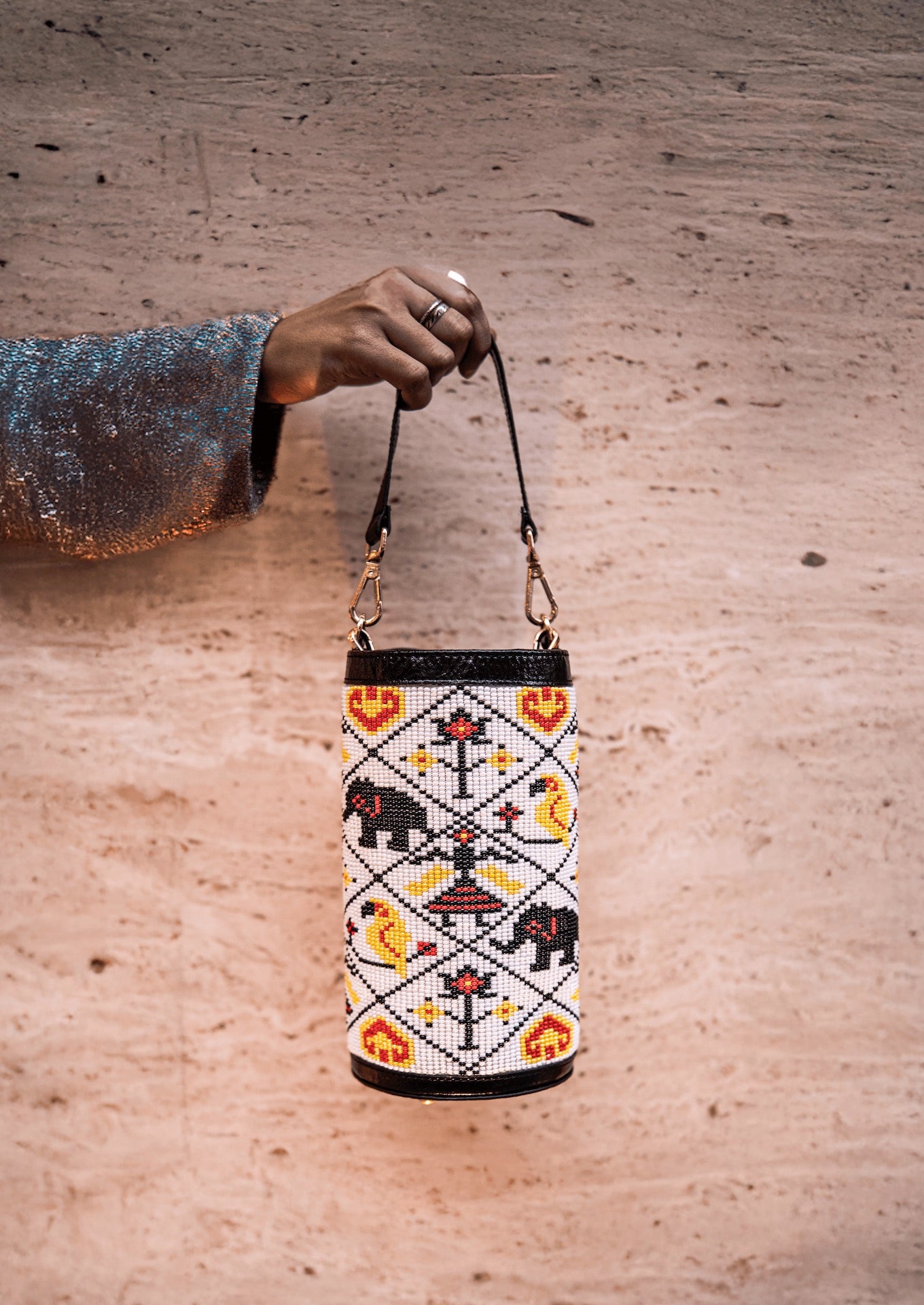 White Variant of Vegan banana fiber bucket bag with intricate Gujarati beadwork, handcrafted premium Indian accessory held by hand.