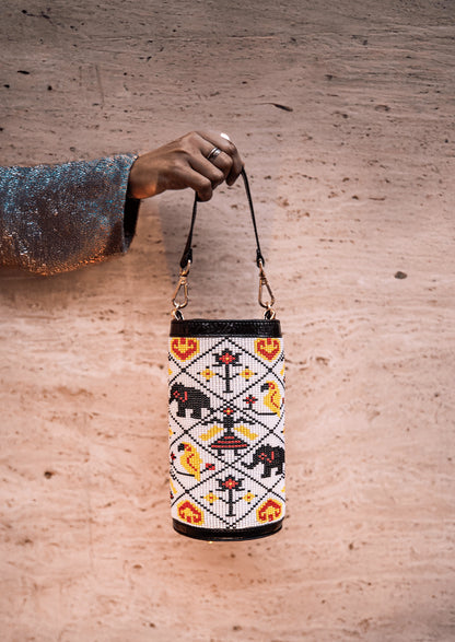 White Variant of Vegan banana fiber bucket bag with intricate Gujarati beadwork, handcrafted premium Indian accessory held by hand.