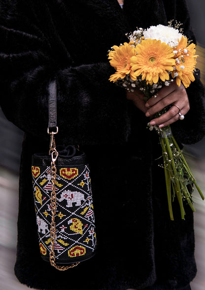 Person wearing Vegan banana fiber bucket bag with intricate Gujarati beadwork, handcrafted premium Indian accessory.