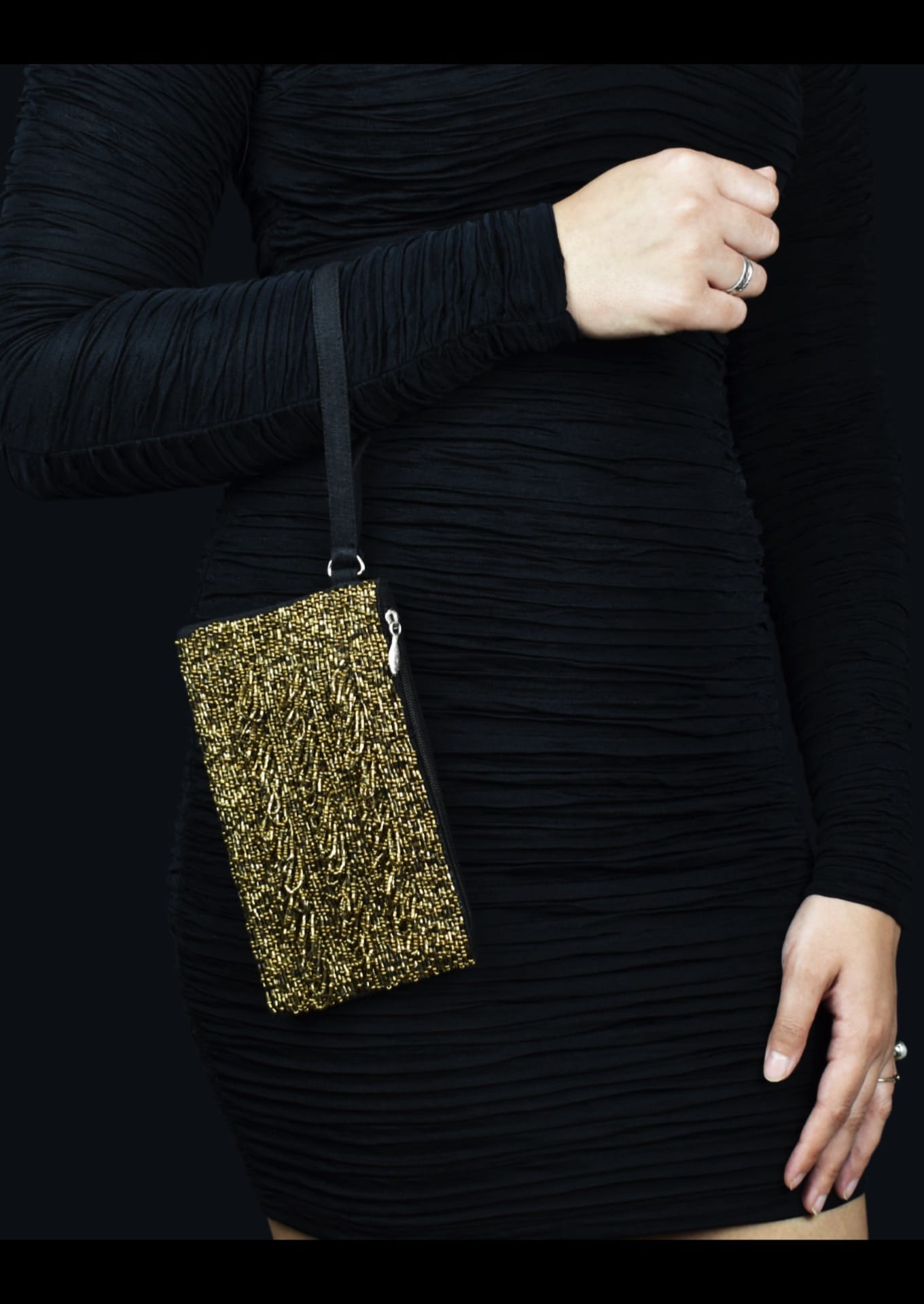 Sparkling gold beadwork on a compact Bareilly artisan pouch worn on hand, authentic Indian fashion.